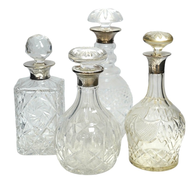 Four silver mounted glass decanters and stoppers, largest 29cm high. Condition - fair to good, one diseased